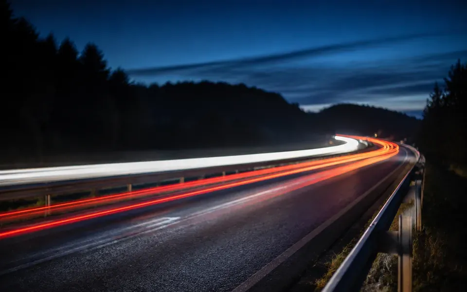 Autoroute de nuit, traînées lumineuses des phares